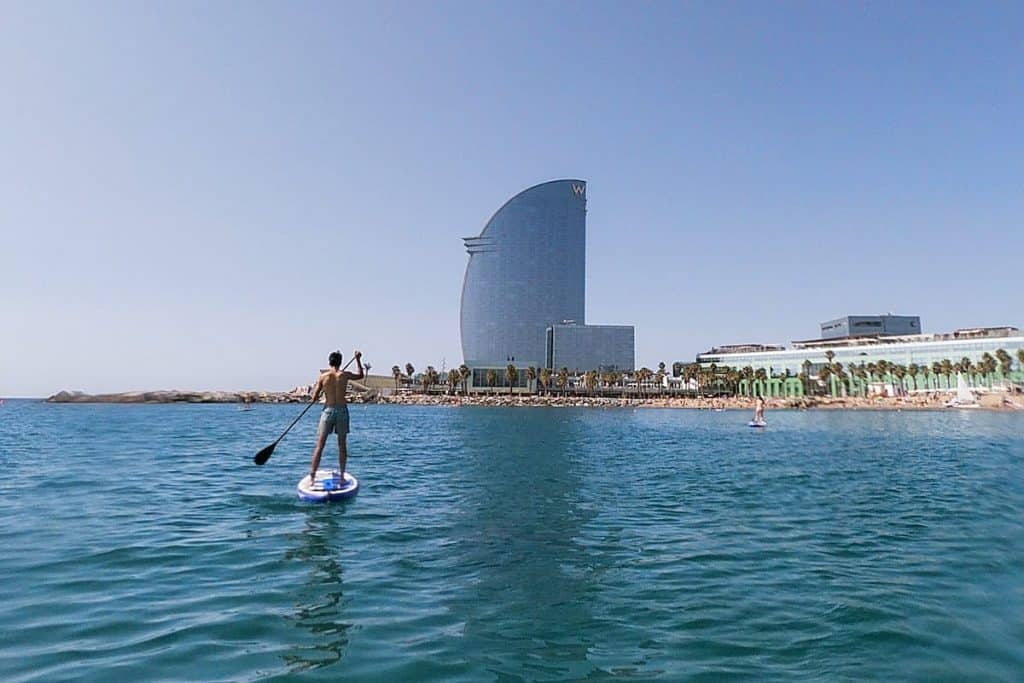 A person practising stand up paddle in front of the Hotel W