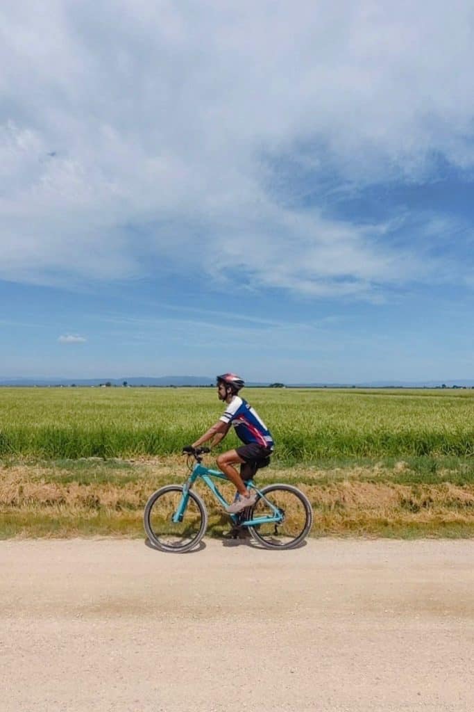 A person exploring the rice fields in Delta de l'Ebre by bike