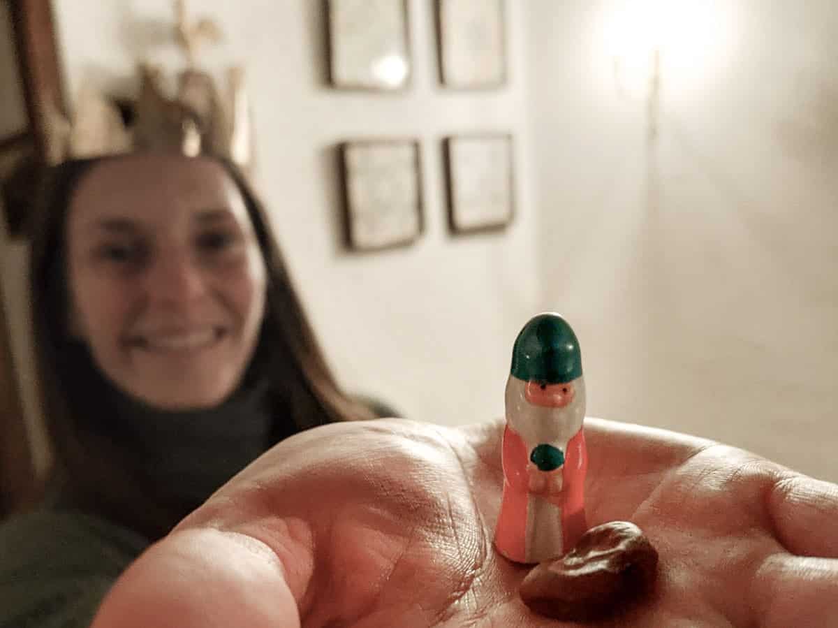 A person showing the king figurine and the broad bean hidden in the Tortell de Reis cake